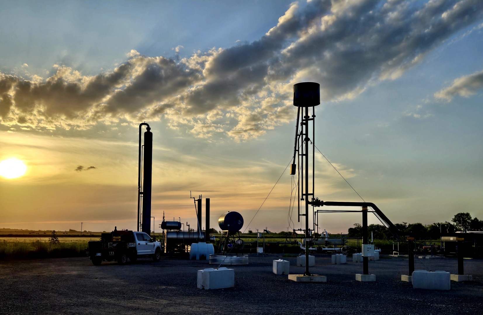 TEG dehydration site silhouetted at sunset